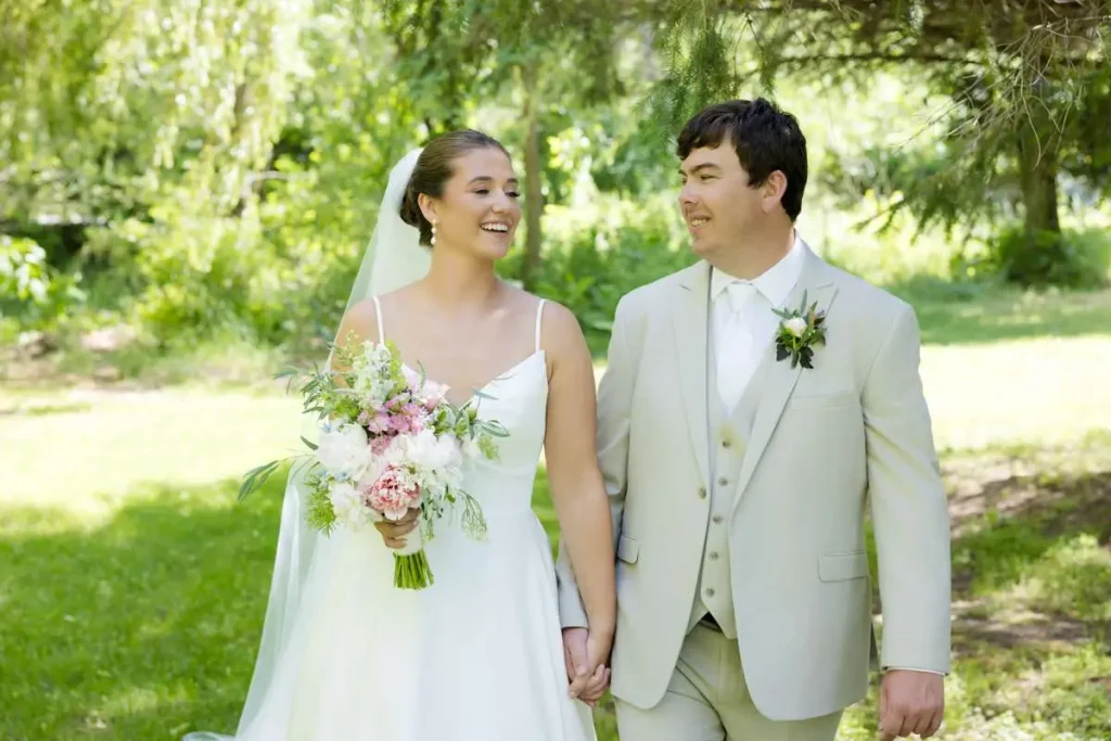 Bride and groom walking in grass at Briar Barns