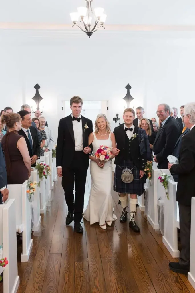 bride being escorted in little white chapel at Morris Estate