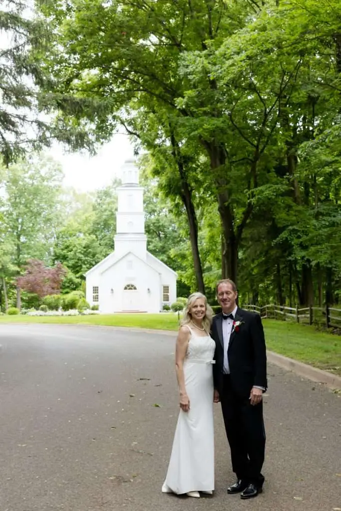 couple on road under trees in front of chapel at Morris Estate